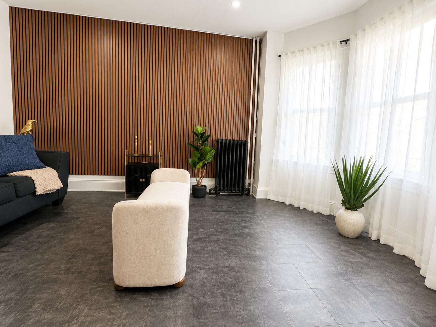 Bright shared lounge with large windows at The Broadway House
